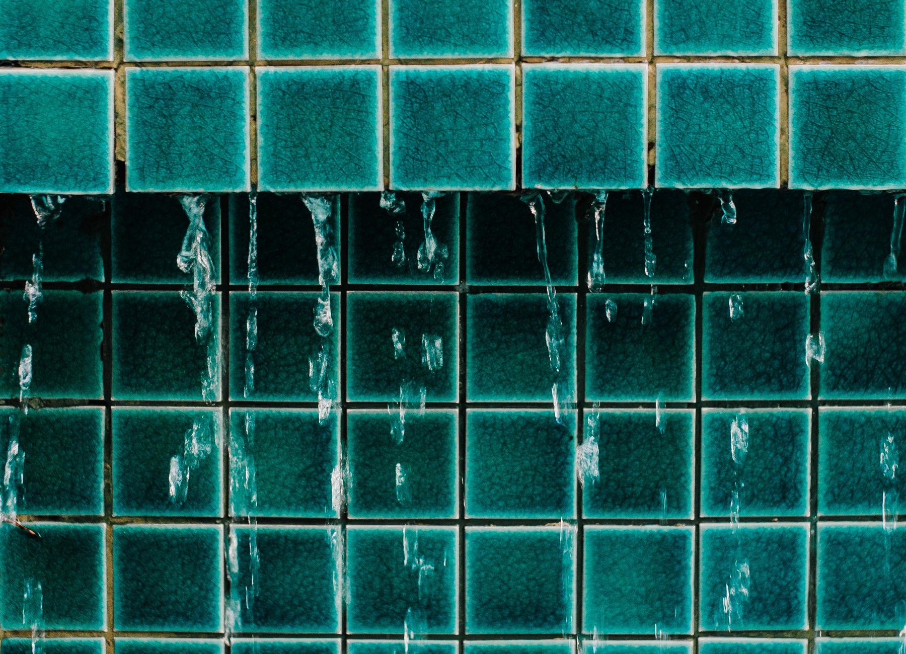 Water seeping down bathroom wall tiles