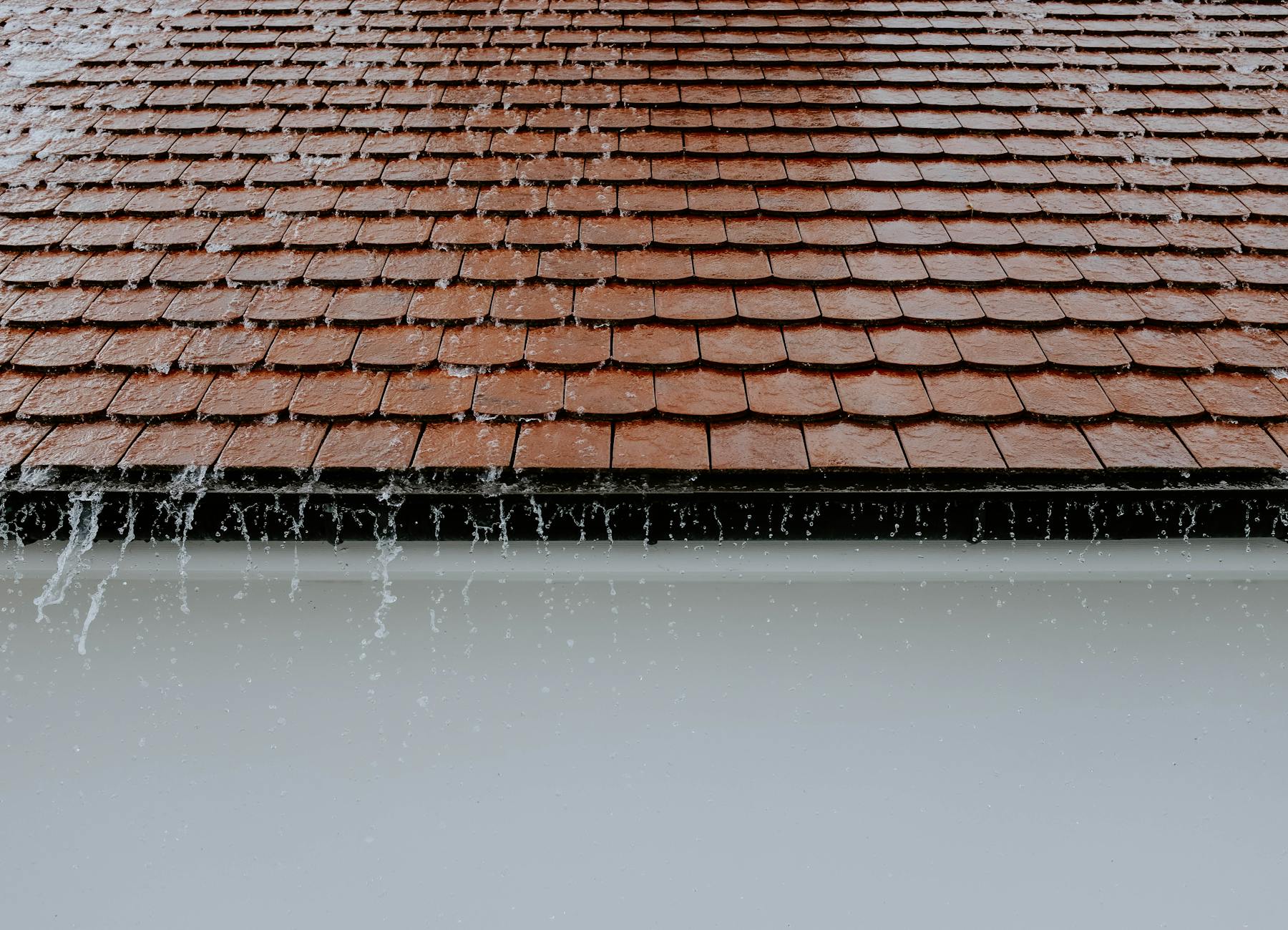 Rainwater overflowing off a roof onto a ponding flat surface